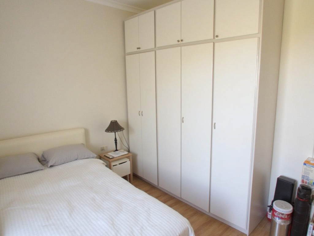 A neatly organized bedroom with minimal clutter